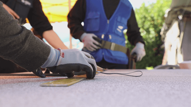 Workers measuring materials with tape measure