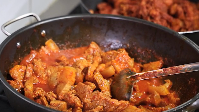 Spicy stir-fried pork cooking in a pan