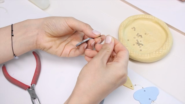 Hands crafting jewelry with beads