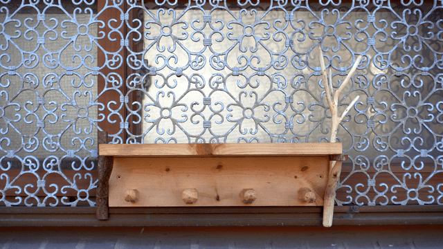 Wooden shelf attached to a patterned window frame
