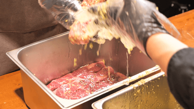 Chefs seasoning meat with avocado sauce