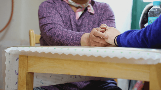 Two people holding hands at a table
