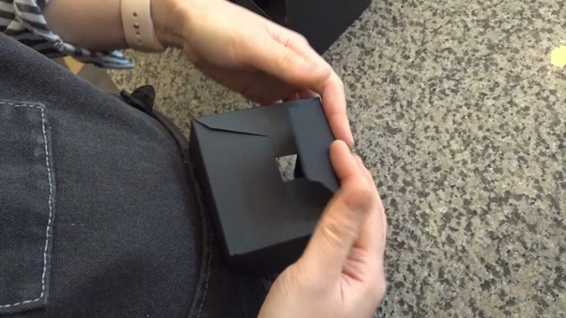 Hands assembling a black paper box