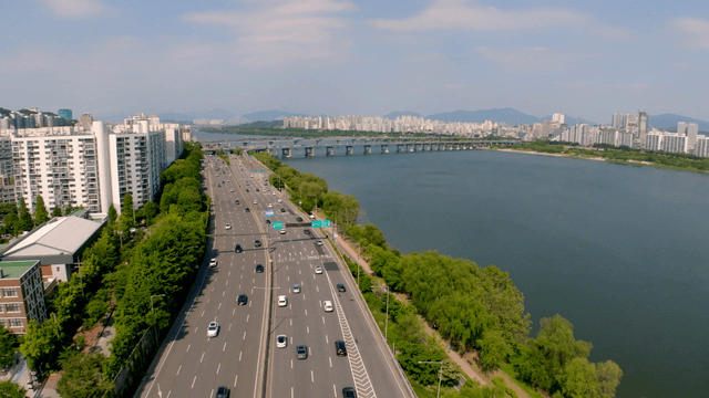 고요한 강 옆의 도심 사이 번화한 고속도로
