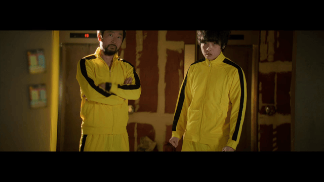 Two people in yellow tracksuits indoors