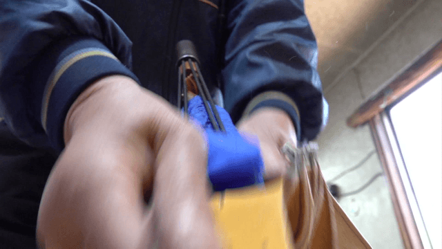Worker shaping leather gloves in workshop
