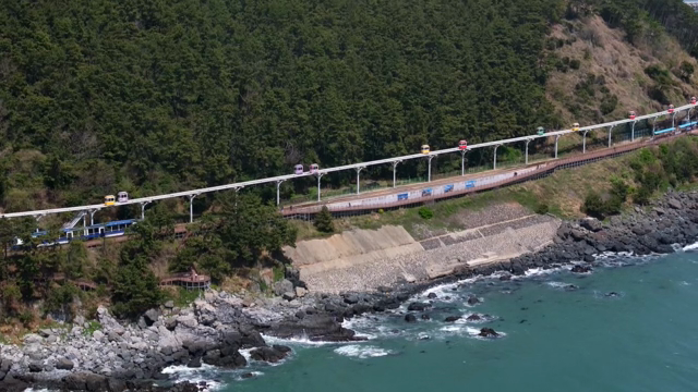 Coastal monorail passing through lush forest