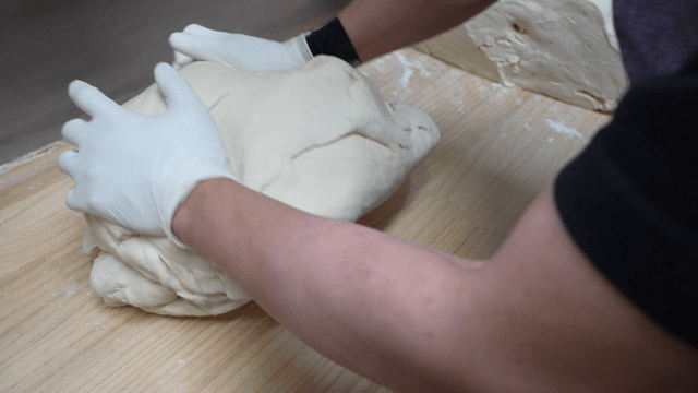 나무 테이블 위에서 반죽을 치대는 손