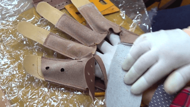 Worker assembling leather glove
