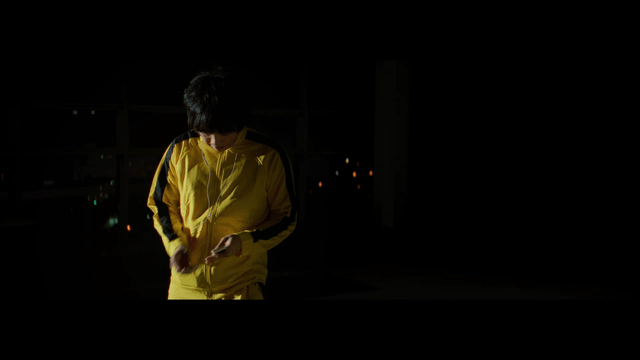 Man wearing a yellow tracksuit with earphones