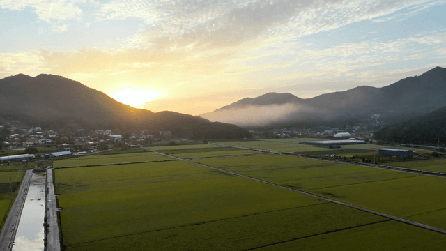 Sunrise over a rural farmland with mountains