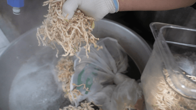 Radish strips added into hot broth in large pot