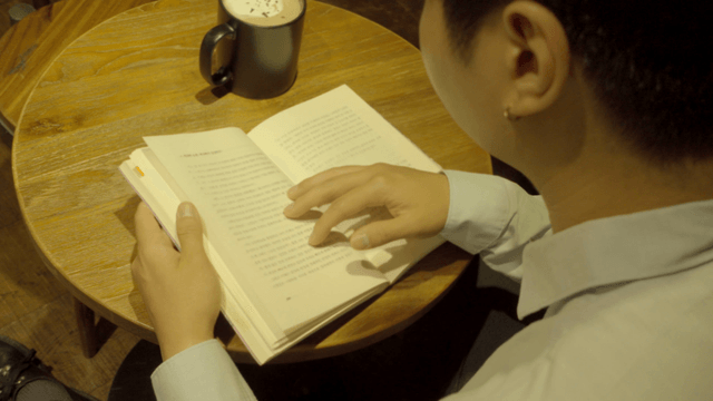 Person reading a book in a cozy cafe