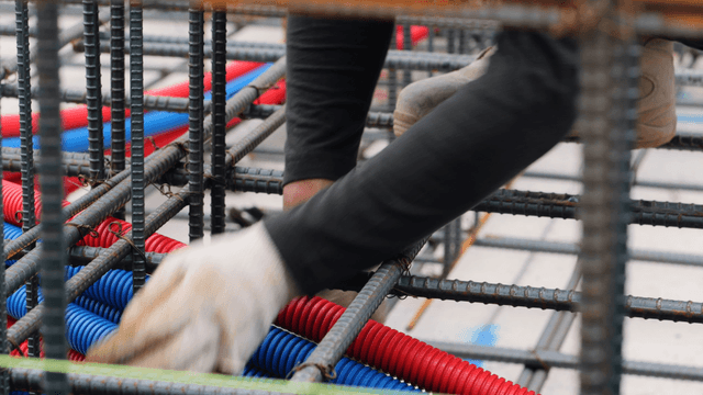 Worker assembling steel bars at a construction site