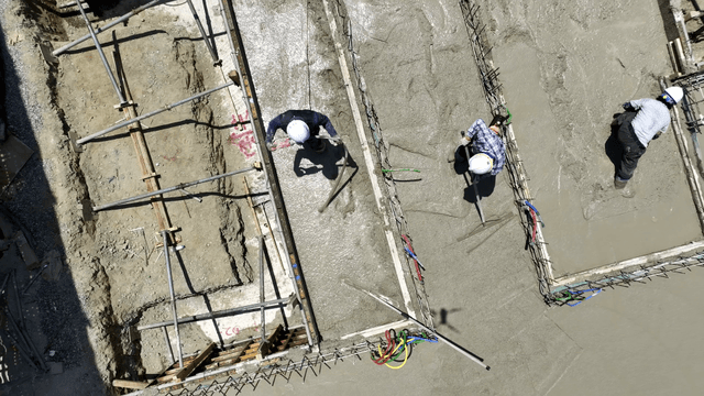 Workers smoothing concrete at a construction site