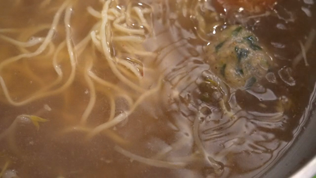 Broth from Korean hot pot with noodles and dumplings