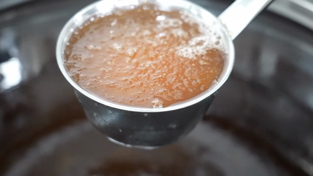 A ladle for stirring soup with ice cubes