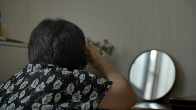 Woman adjusting hair in front of a mirror