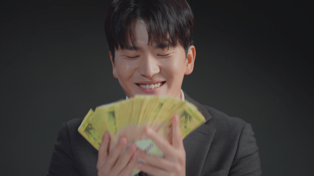 Man in a suit smelling a stack of money