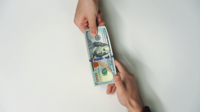 Hands exchanging currency bills