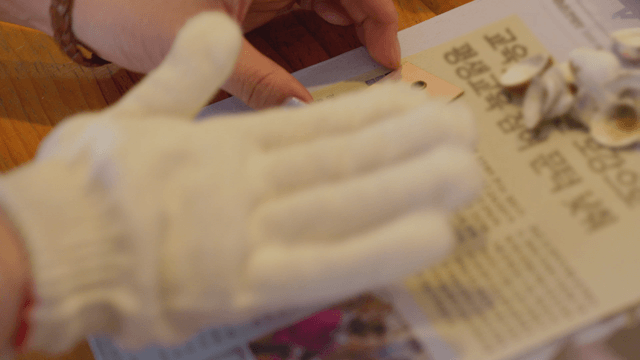 Gloved hands dyeing a tag on a craft table