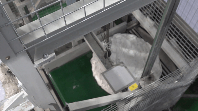 Factory machine inspecting pile of white fabrics