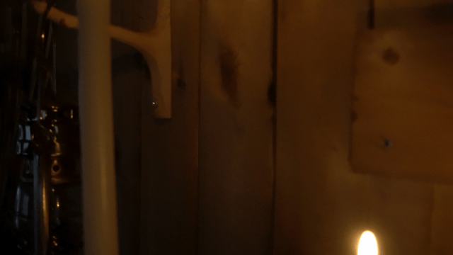 Long and short candles burning in a dark room