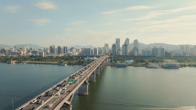 A bridge over a river with city skyline