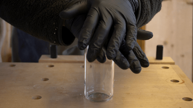 Craftsman closing and inspecting a glass jar