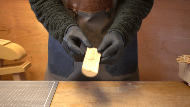 Artisan inspecting wooden rods in workshop