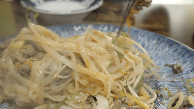 Plate of stir-fried rice noodles with vegetables and beef