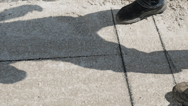 Workers measuring and marking concrete