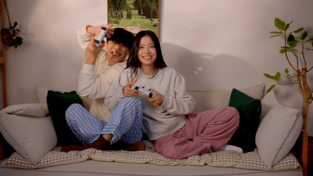 Couple playing console video game on sofa