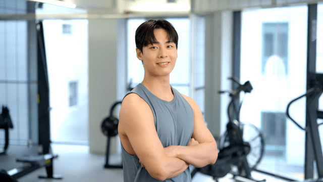 Young man smiling with arms crossed in gym