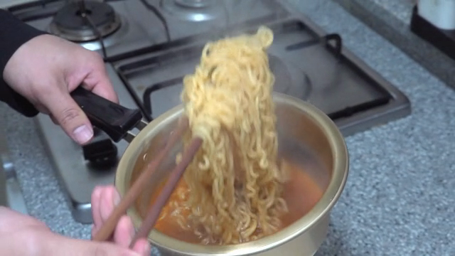 A person who cools noodles by lifting them with chopsticks