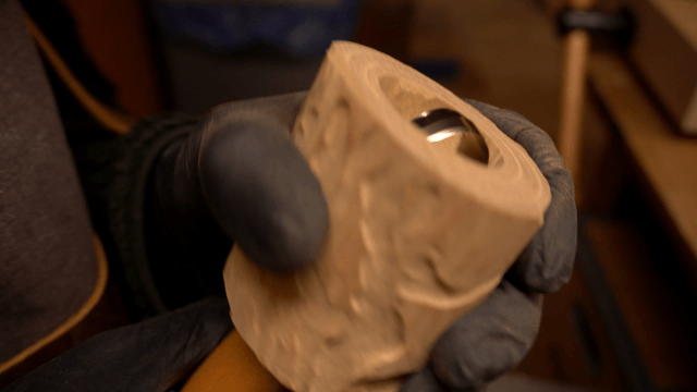 Artisan carving wood with a curved chisel