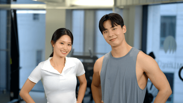 Smiling couple facing forward at the gym