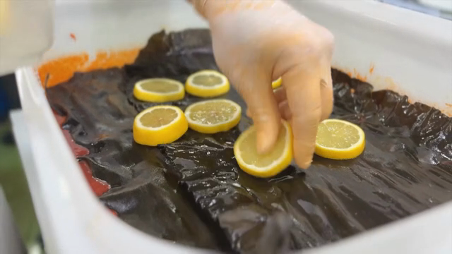 Placing lemon slices on marinated kelp