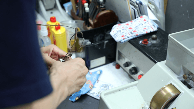 Person repairing glasses at a workbench