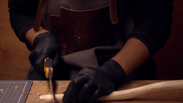 Person carving wood with precision