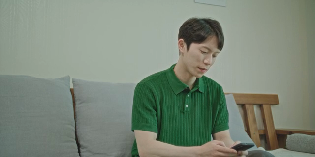 소파에서 스마트폰을 사용하는 남자