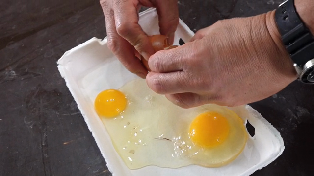 Cracking eggs into a carton