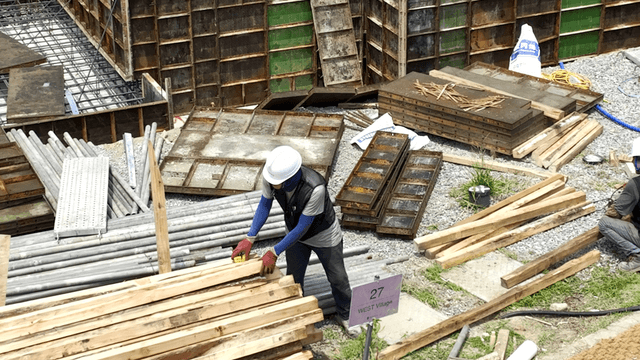 Construction workers handling wooden planks