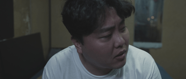 Tired man sitting on a bed indoors