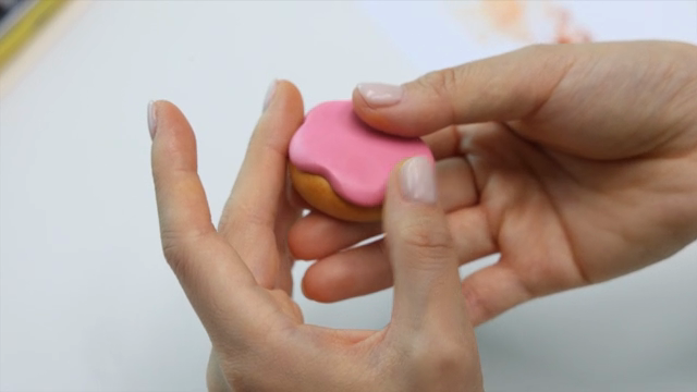 Hands shaping a donut out of clay