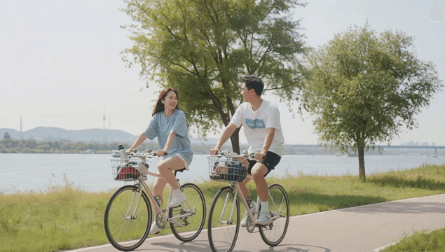 Couple cycling along a riverside path