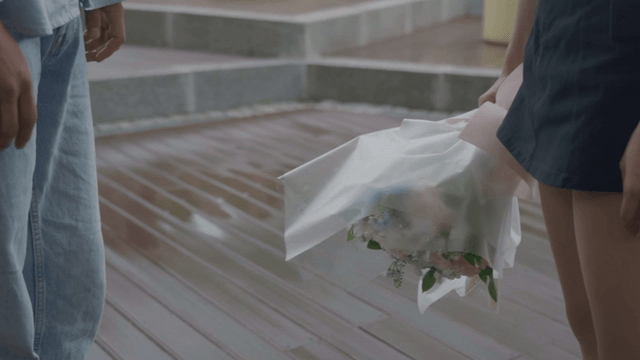 Woman giving strength to a man and holding a bouquet of flowers