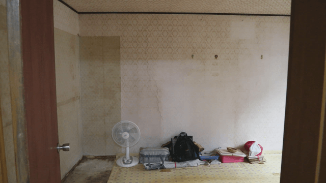 Empty room with a fan and bags