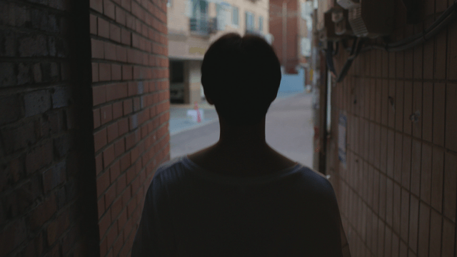 Man walking through a narrow alleyway