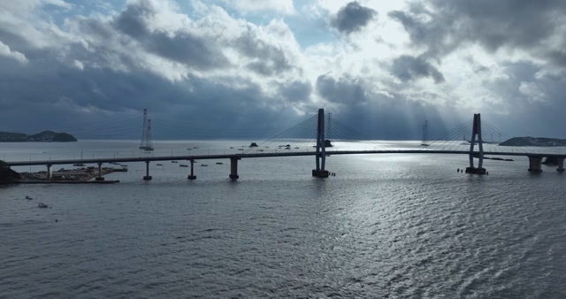 A bridge over a calm sea with clouds
